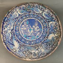 An interesting 19th century or earlier Eastern tin glazed pottery charger with a signature on the