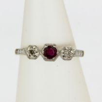 An 18ct yellow and white gold ring set with and round cut ruby and diamonds, (J)