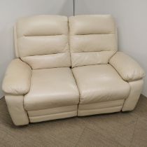A cream leather two seater settee with fold out leg rests.