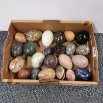 A collection of polished stone and wooden eggs, largest 7.5cm.