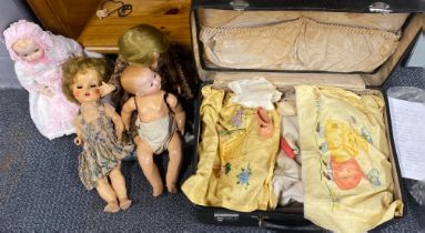 A group of four vintage dolls and a case of dolls clothes, fabrics, etc.