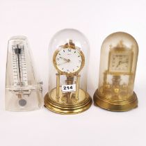 Two anniversary clocks under domes and a metronome, tallest H. 22cm.