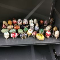 A collection of enamelled and other eggs, largest 7.5cm.