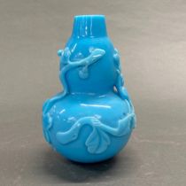 A blue Peking glass gourd vase with relief decoration, H. 17cm.