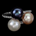 A 925 silver ring set with a black pearl, a cream pearl and a pearl and white stone set