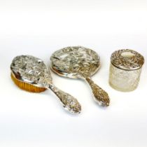 An Art Nouveau silver (continental, tested) backed mirror and hair brush together with a silver-