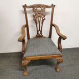 A carved oak and upholstered child's chair with ball and claw feet, H. 75cm.