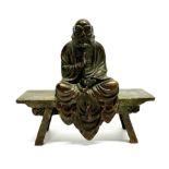 A lovely Chinese cast copper bronze figure of Da Mo meditating on a bench, W. 11.5cm. H. 10cm."