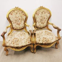 A pair of early 20th C carved gilt wood armchairs, H. 106cm.