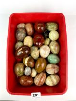 A collection of polished stone and wood eggs, largest 8cm.