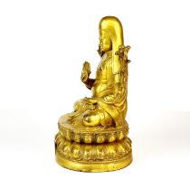 A Tibetan gilt bronze figure of a seated Lama, H. 23cm.