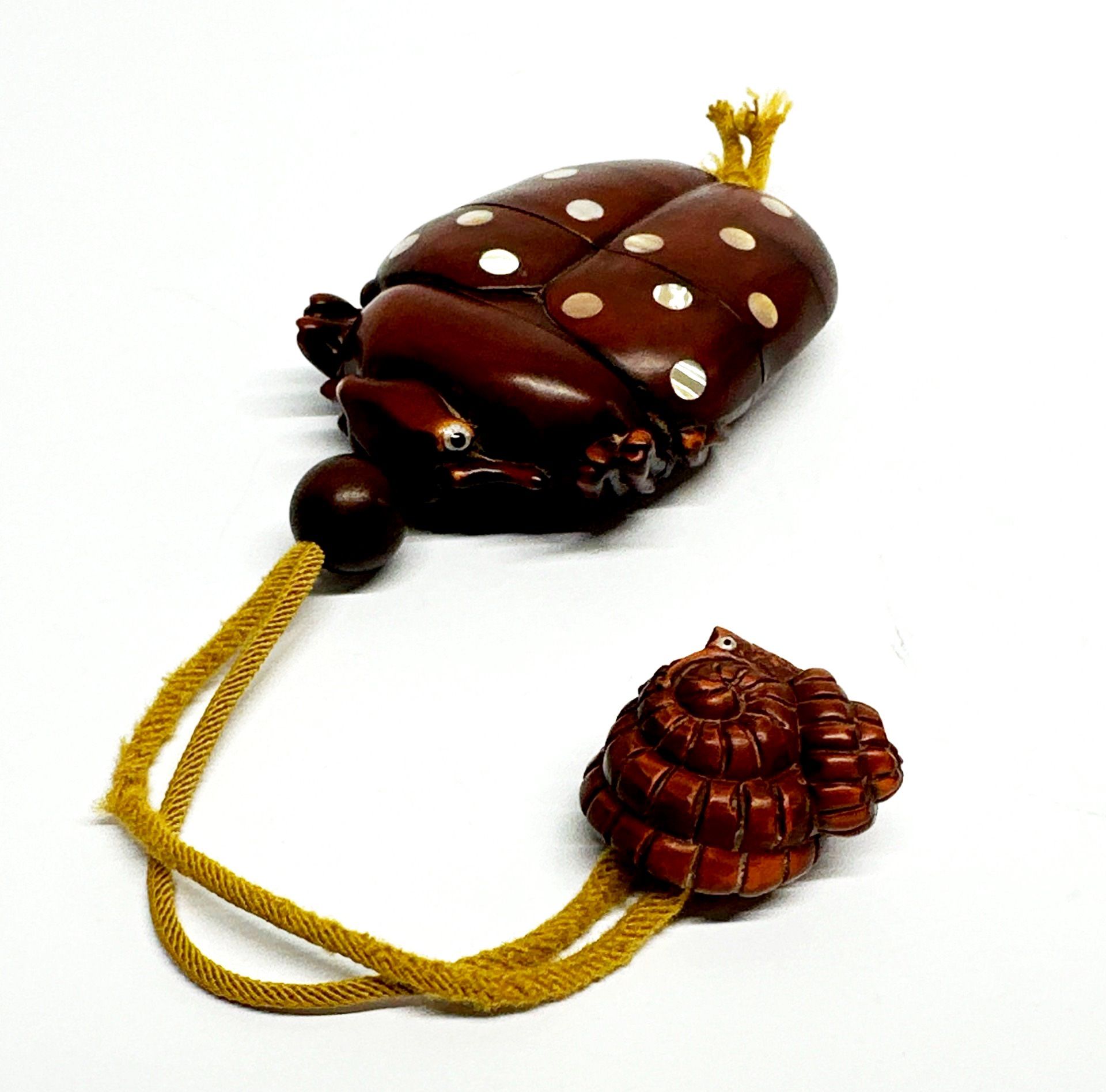 A Japanese carved fruitwood inro of a ladybird inset with mother of pearl with a shell netsuke and