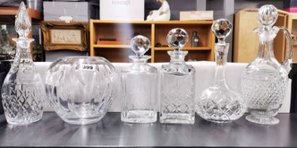 A group of five cut crystal decanters and a Baccarat crystal bowl.