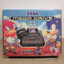 A boxed Sega Mega Drive 2 with two controllers and Sonic 3, Theme Park, Comix Zone and Robocop vs