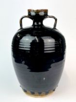 A Chinese black glazed pottery jar (18th C. or earlier) drilled to base and A/F to rim with