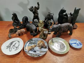 A group of bear related figures and items including carved hardwood bookends and plates, tallest