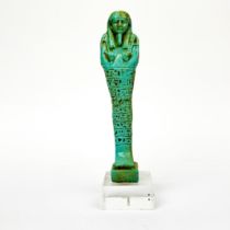 An Egyptian glazed stoneware ceramic figure of a mummy mounted on a clear Perspex base, probably