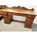 An impressive four drawer mahogany buffet sideboard with carved decoration and flamed mahogany
