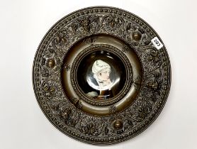 A 19th C. German hand-painted porcelain plate in a hammered brass frame.