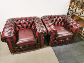 A pair of oxblood red leather chesterfield armchairs, H. 70cm W. 105cm D. 90cm.