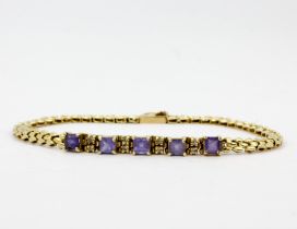 A 14ct yellow gold (marked 14K) tanzanite and diamond set bracelet, L. 19cm.