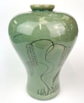 A Chinese incised and celadon glazed pottery vase, H. 19cm."