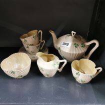 An Early Belleek Irish porcelain teapot, sugar bowl, milk jug and three cups with three saucers.