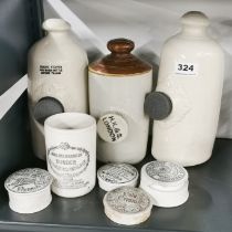 Three stoneware hot water bottle with a group of advertising pot lids.