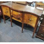 A bow fronted cross banded and inlaid mahogany sideboard with lion head handles and plate glass top,