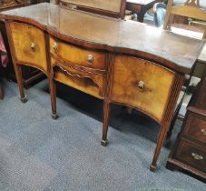 A bow fronted cross banded and inlaid mahogany sideboard with lion head handles and plate glass top,