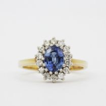 A hallmarked 9ct yellow gold cluster ring set with an oval cut blue topaz surrounded by diamonds, (