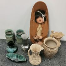 A group of vintage ceramic items with a native American doll in a papous.