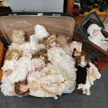 A collection of porcelain head dolls with a dolls prams.