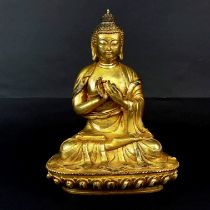 A Sino-Tibetan gilt bronze figure of a seated Buddha, H. 22cm.