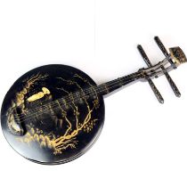 A hand-painted and lacquered wooden wall decoration of an Oriental instrument, 58cm.