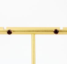 A pair of 9ct yellow gold garnet set stud earrings, dia. 0.4cm.