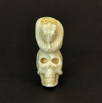 A hand carved stag antler skull with detailed snake sat on top, H. 5.5cm.