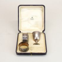 A boxed hallmarked silver eggcup and napkin ring by Asprey of London, together with a further silver