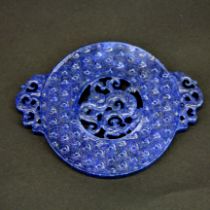A Chinese carved blue hardstone disc decorated with a dragon, W. 9.5cm.