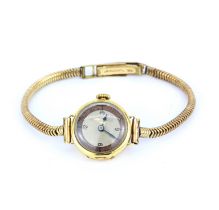 A lady's 18ct yellow gold wrist watch on a rolled gold strap.