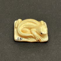 A carved fossilised Mammoth tusk signed Netsuke of a Lizard, 2.5 x 1.8cm.