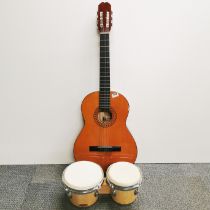 A Balmeria Spanish guitar and case with a pair of bongo drums.