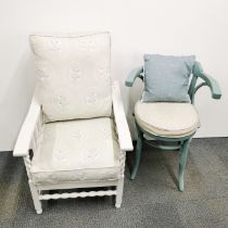A cream finished reclining armchair with floral upholstered cushions together with a teal painted