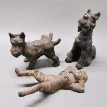 Two cast iron dog door stops and a cast iron boot jack, tallest H. 21cm.