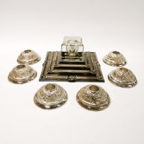 A silver plated inkwell with six plated candlesticks.