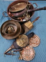 A large antique copper pan and other metalware.