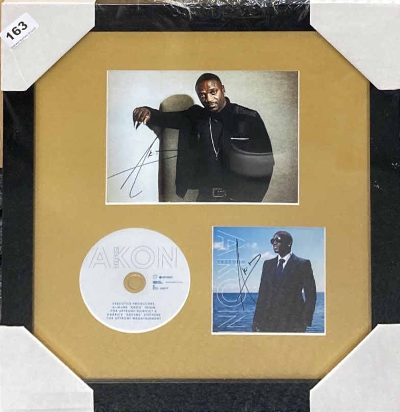 Autograph interest: A framed autographed photograph and CD cover by Akon. Frame size 42 x 42cm.