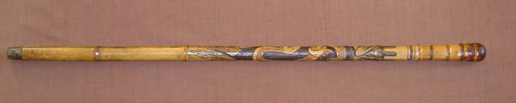 A heavy bamboo walking stick carved with an elaborate oriental design of an eagle and large snake in
