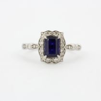 A 950 platinum ring set with an emerald cut sapphire and diamonds with diamond set shoulders, (L.