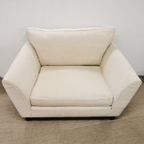 A cream snuggle chair/ loveseat, L. 130cm D. 100cm H. 90cm.